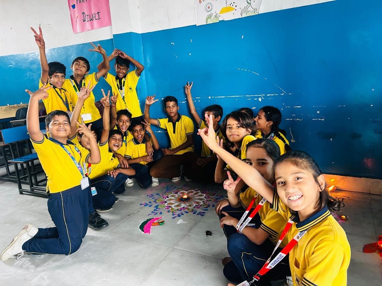 Students celebrating Diwali with a rangoli