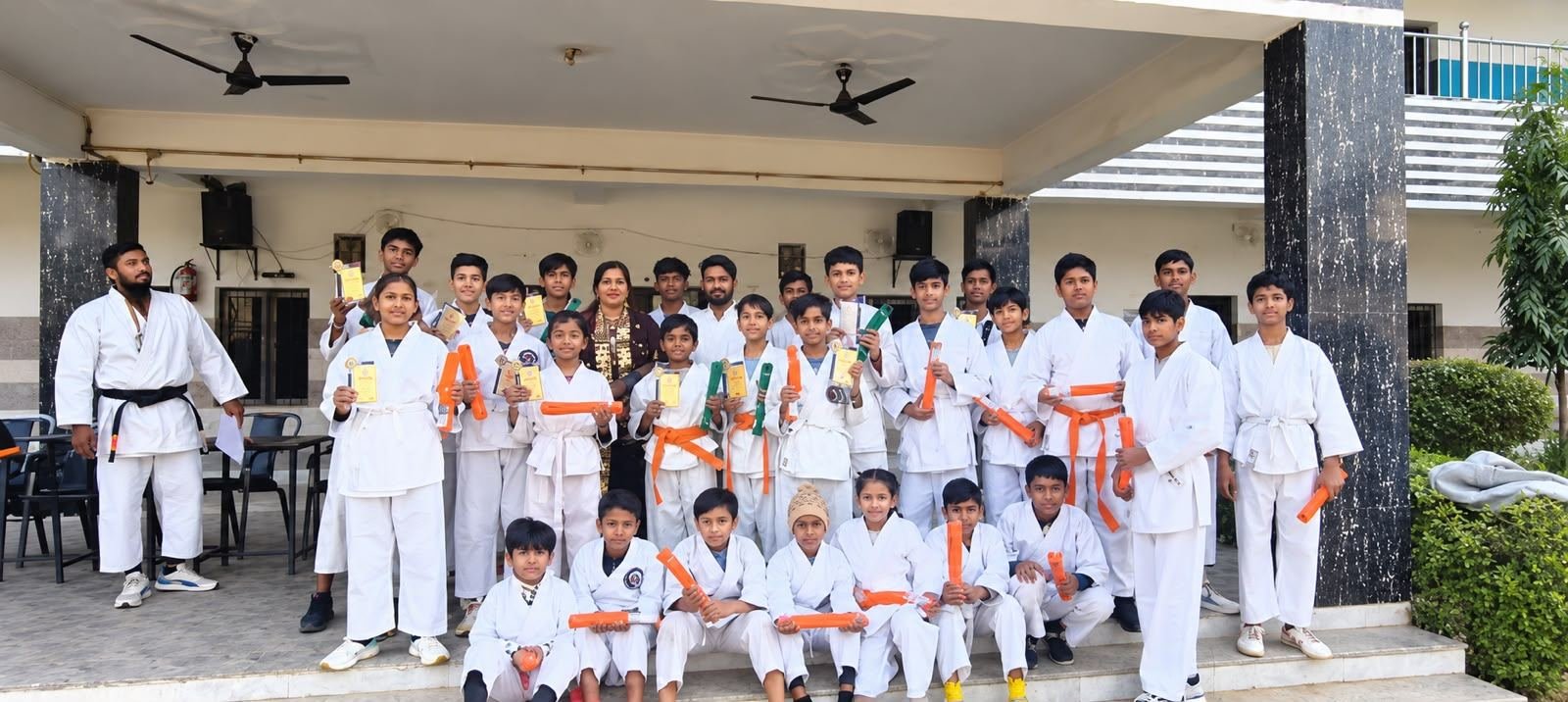 Students with karate belts and certificates